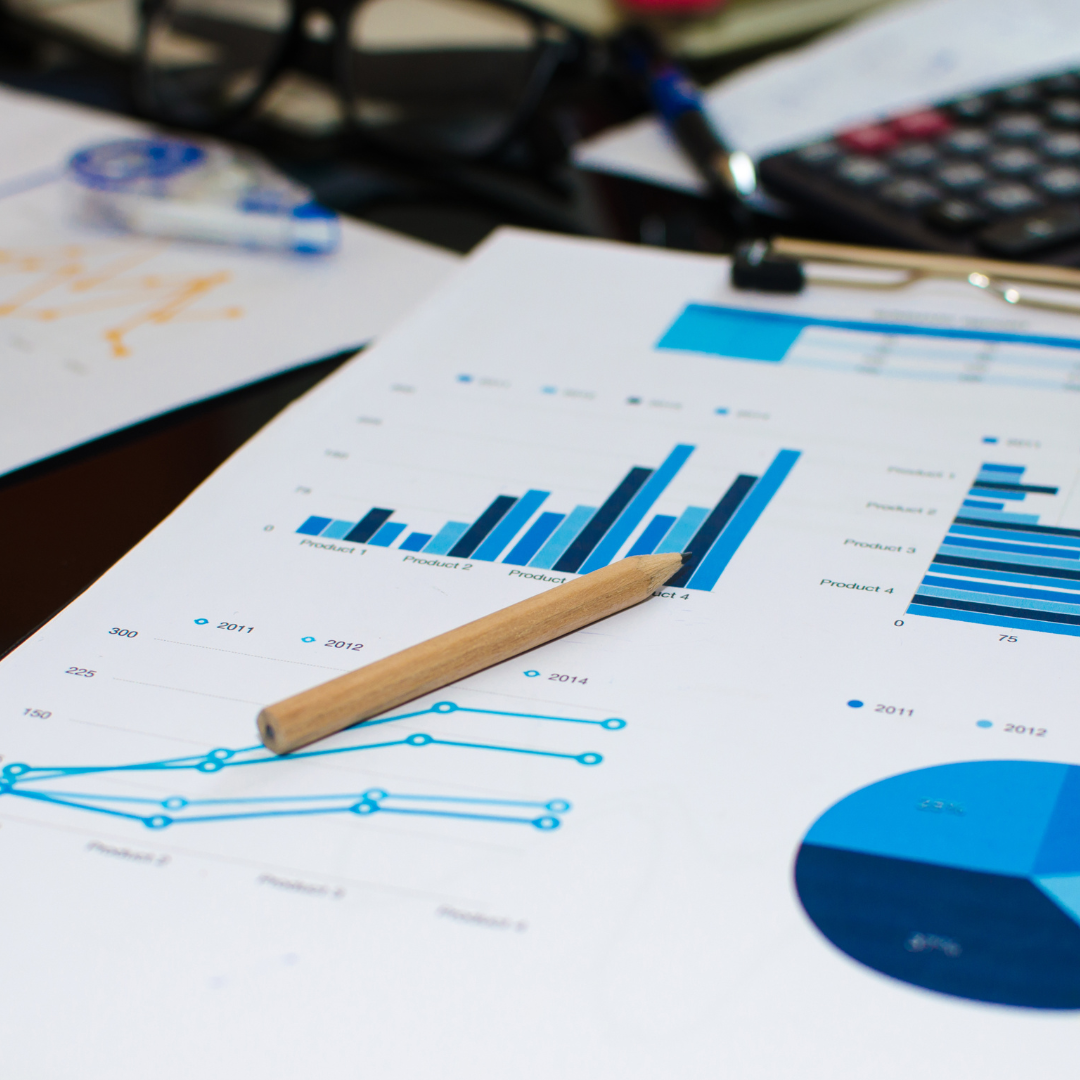 A desk with business charts, graphs, and a pencil, symbolizing financial analysis and data interpretation.