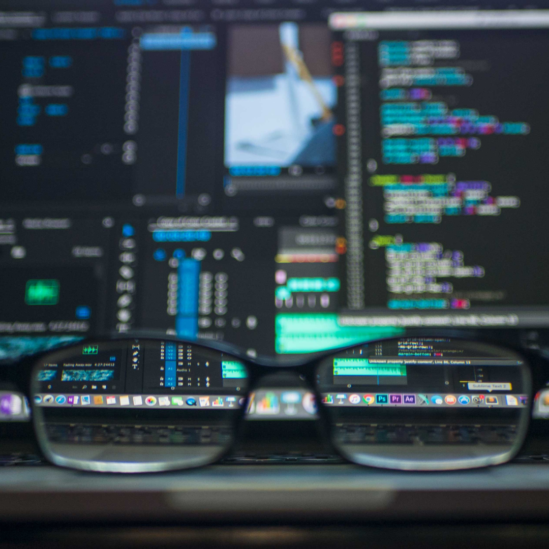 Close-up of glasses reflecting code and data, showcasing Aptimized's tech focus.