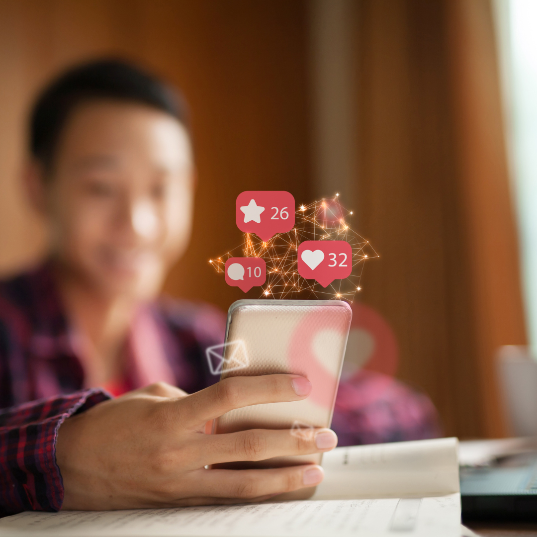A person interacts with a smartphone, surrounded by floating social media icons, emphasizing digital engagement.
