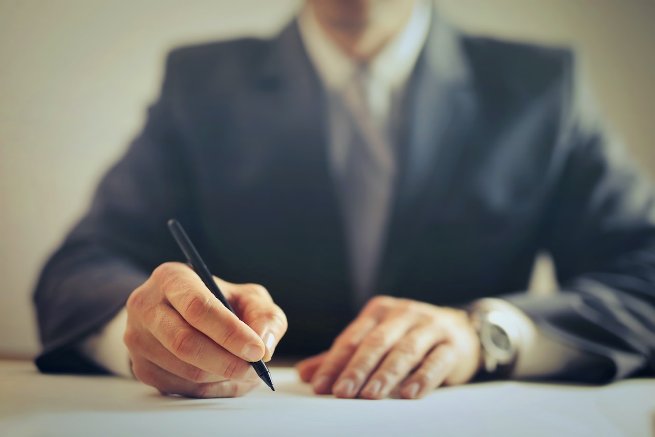 A business man writing on a plane paper