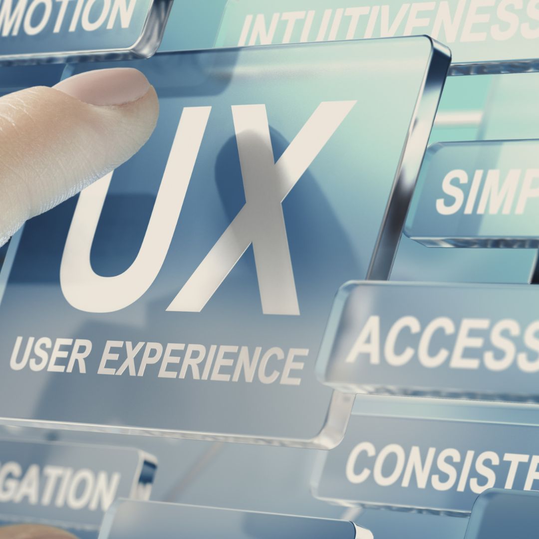 Finger selecting "UX" (User Experience) on a digital interface.