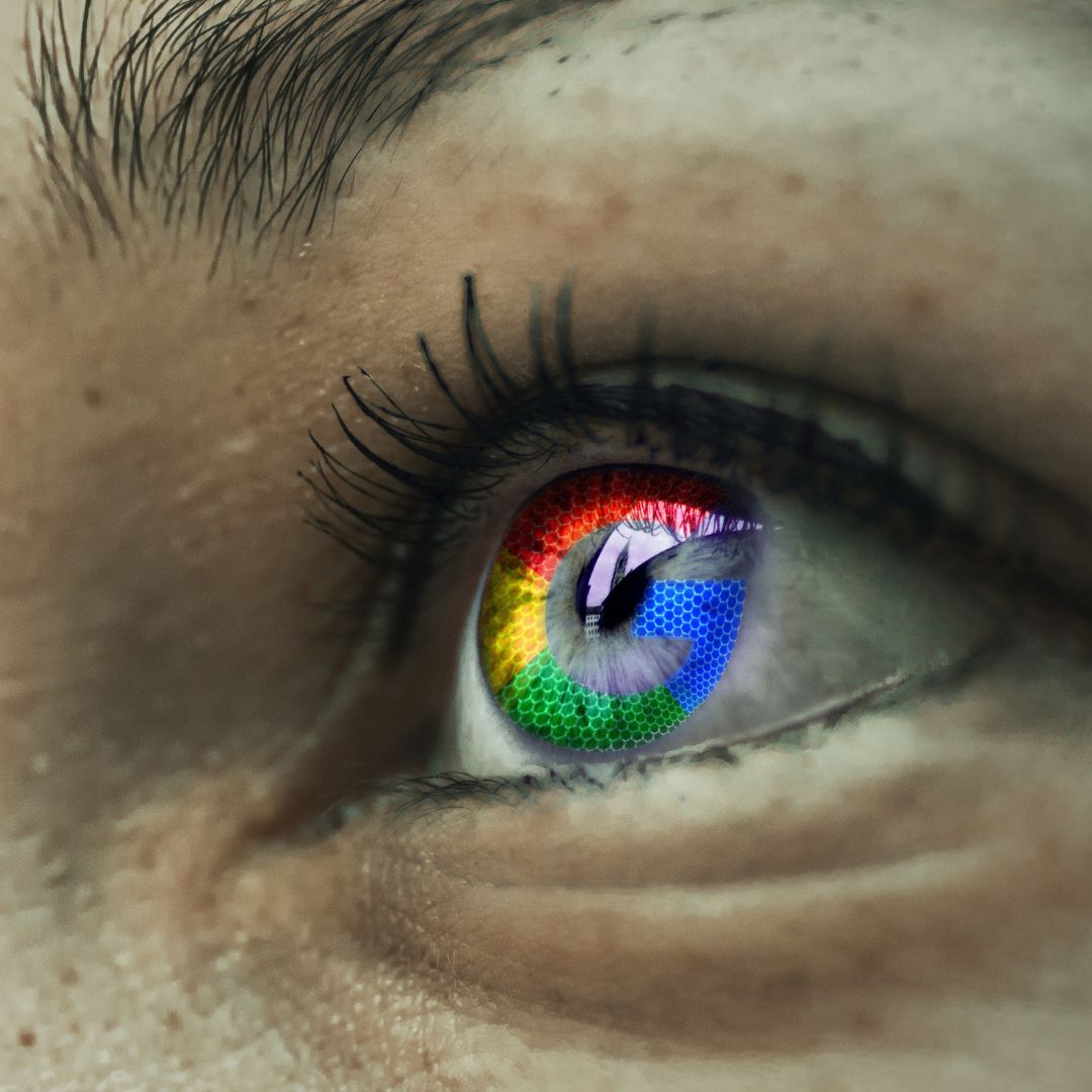 Close-up of an eye with the Google logo reflected in the iris, symbolizing data tracking.
